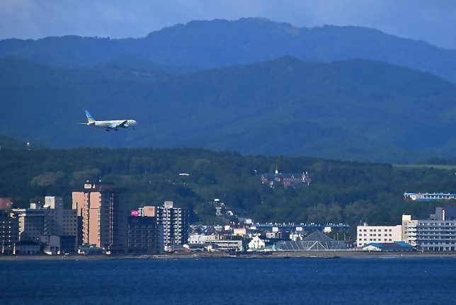 トラピスティヌ修道院と函館空港に着陸する旅客機が見える